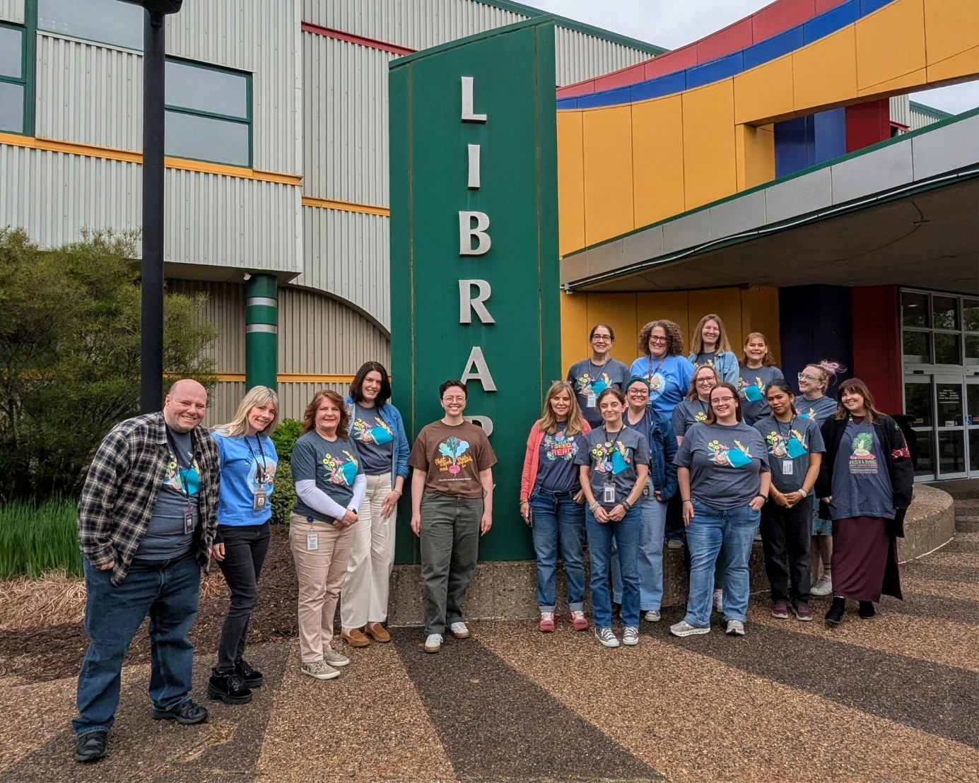 Bettendorf Library staff lined up outside the library entrance intheir Summer Reading Program T-shirts