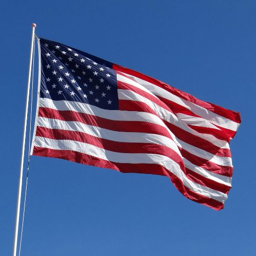 The American flag flying in front of a blue sky